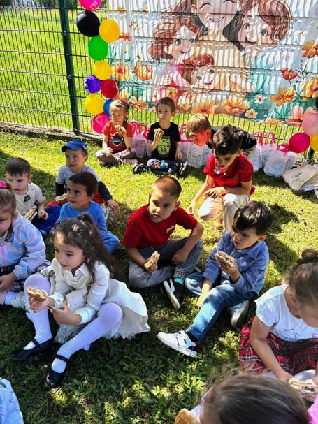 Die Kindergruppe bedienen sich an den Brötchen.
