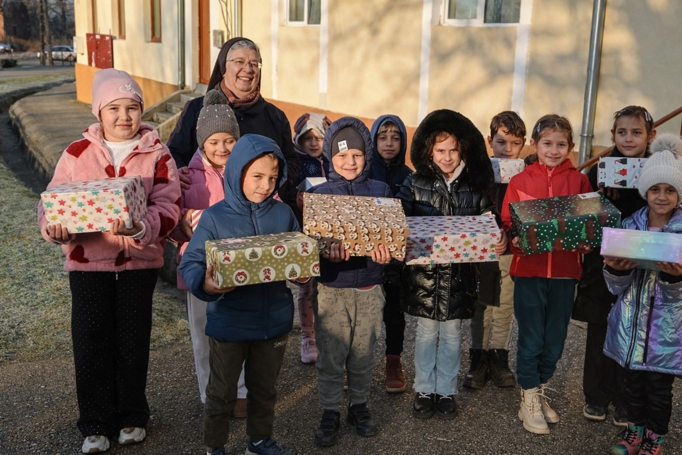 Schwester Marie Therese Gabor beim Verteilen der Weihnachtspakete mit mehreren Kindern, die ein Geschenk in der Hand halten